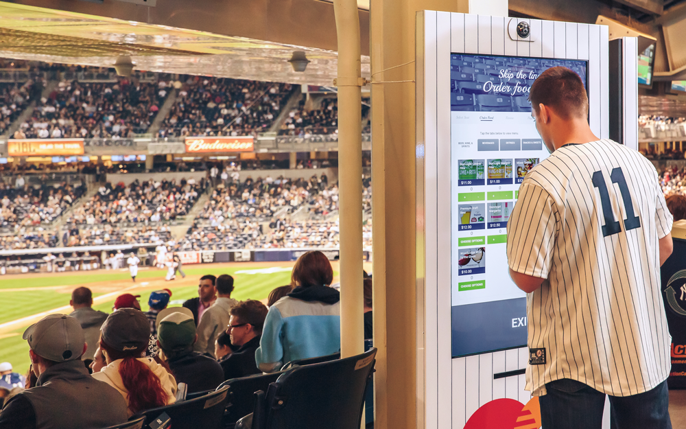 Fans and a food-ordering kiosk at Yankee Stadium